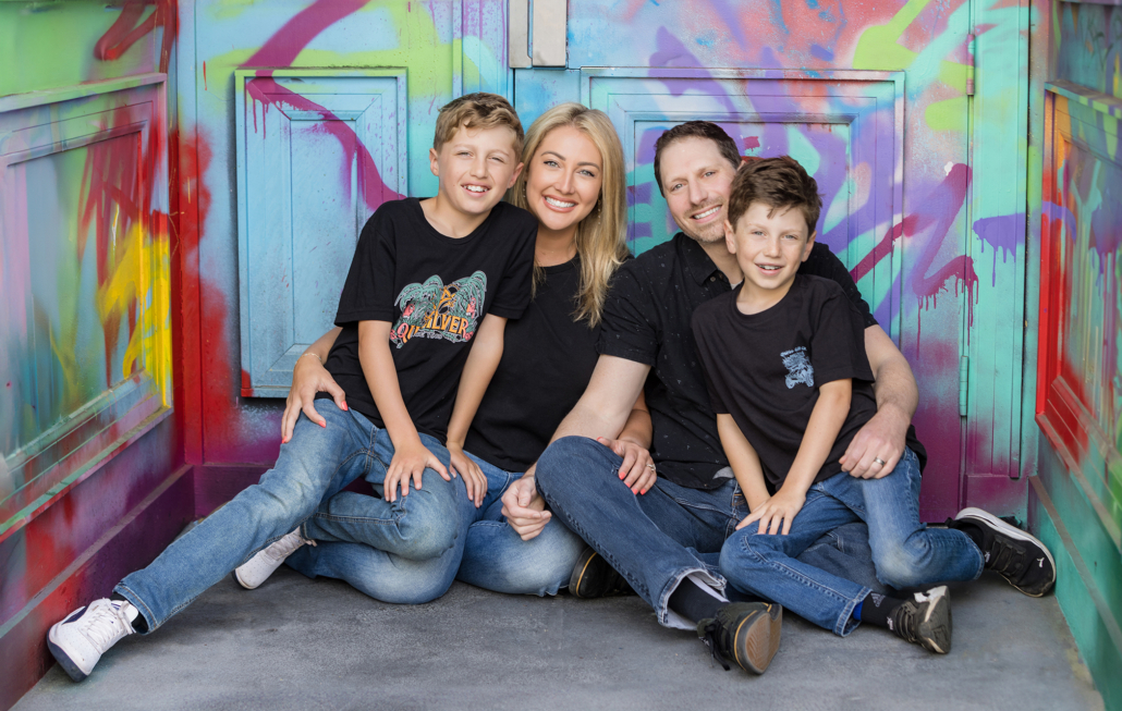 Orange County Urban Family photo in a doorway with bright colored graffiti.