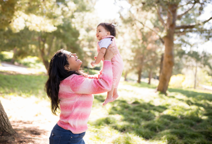 Mother lifting her baby in the air for their family photography