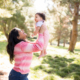 Mother lifting her baby in the air for their family photography