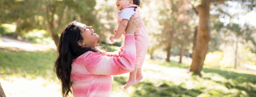 Mother lifting her baby in the air for their family photography