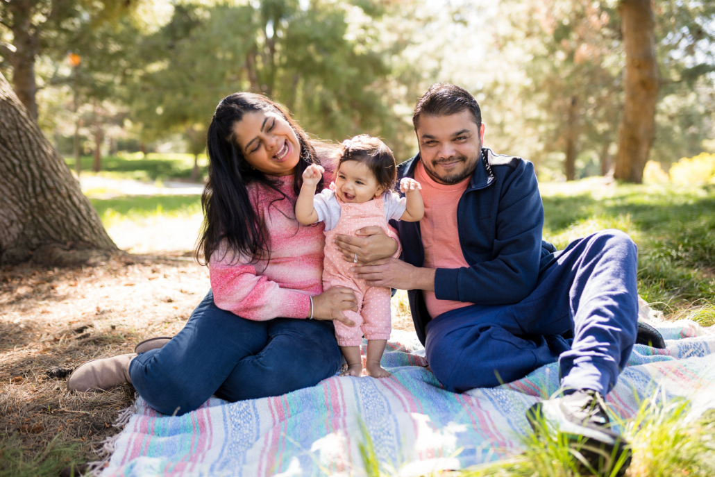 Udani family relaxing on a blanket in Jeffrey Open Spaces