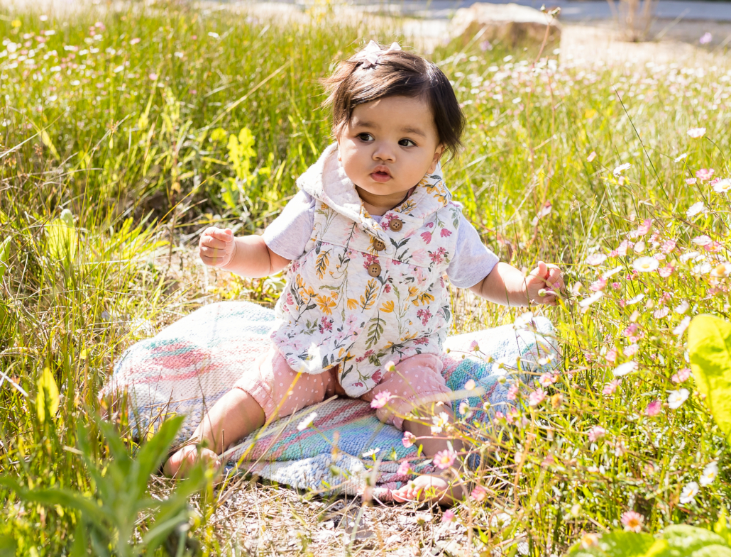 One-year-old Udani child sitting in the grass