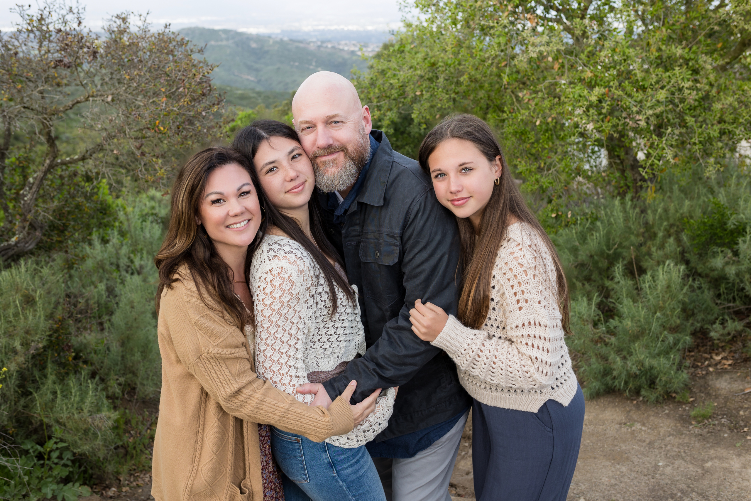 a family of four posing together for their family photoshoot outdoor at alta laguna