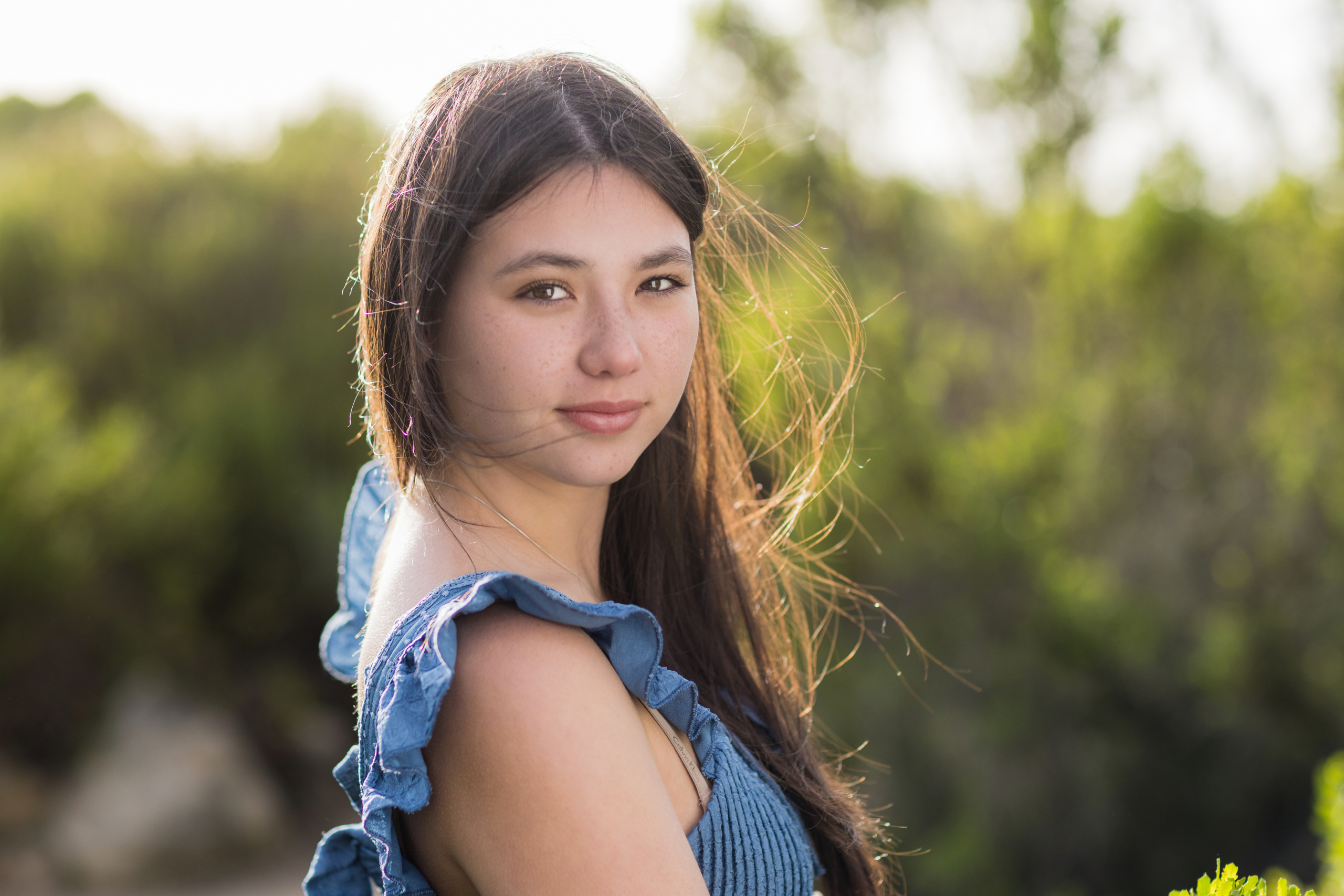 Wind blowing through the hair of a high school senior during outdoor portraits.