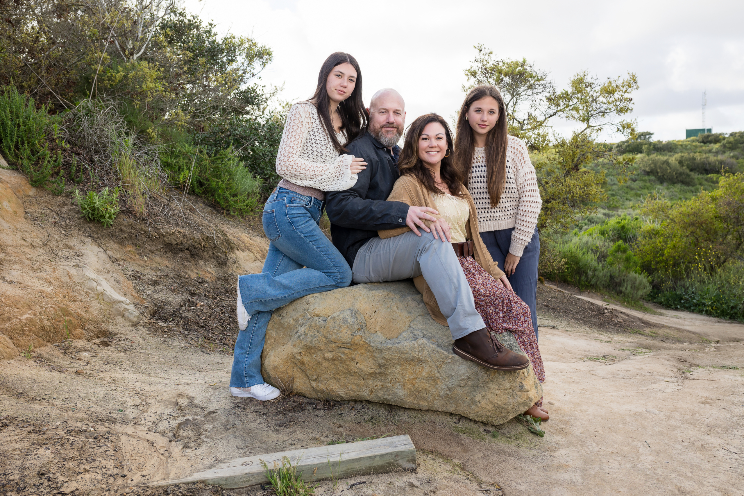 Family dressed in casual outfits, enjoying their time together outdoors.