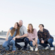 Family of four enjoying their photoshoot on the sandy shores of San Clemente Beach.