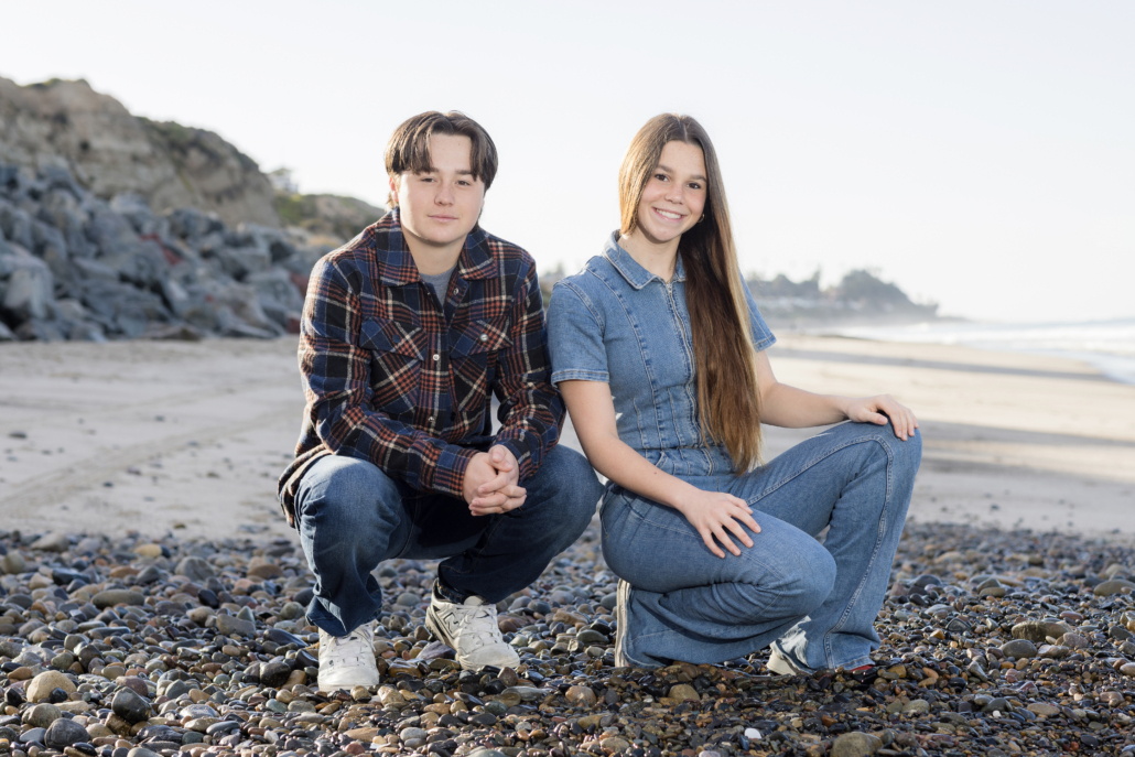 Siblings in a seated pose, captured by a Laguna Beach photographer at San Clemente State Beach.