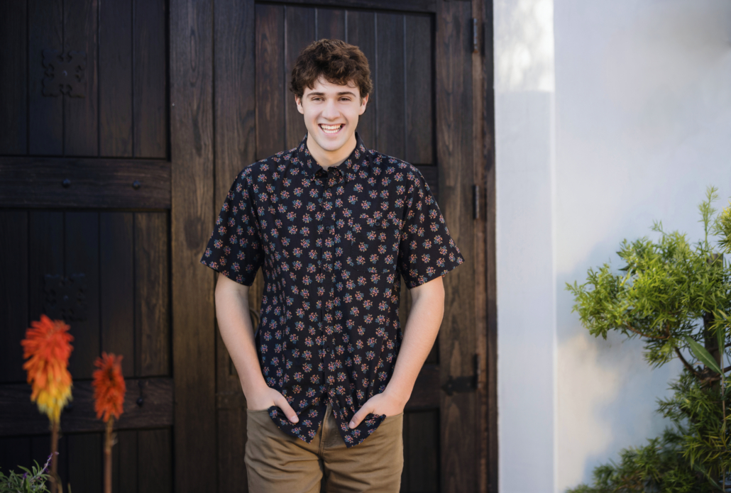 Senior guy standing confidently with hands in his pants pockets, dressed in a casual button-up shirt and jeans